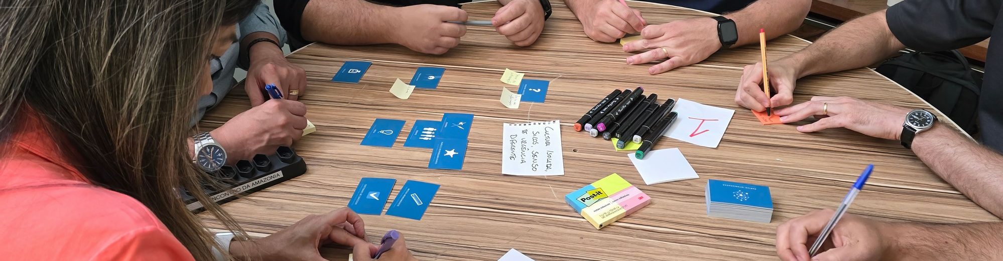 Atelier à l'intelligence collective en entreprise avec des participants utilisant des cartes et des supports créatifs
