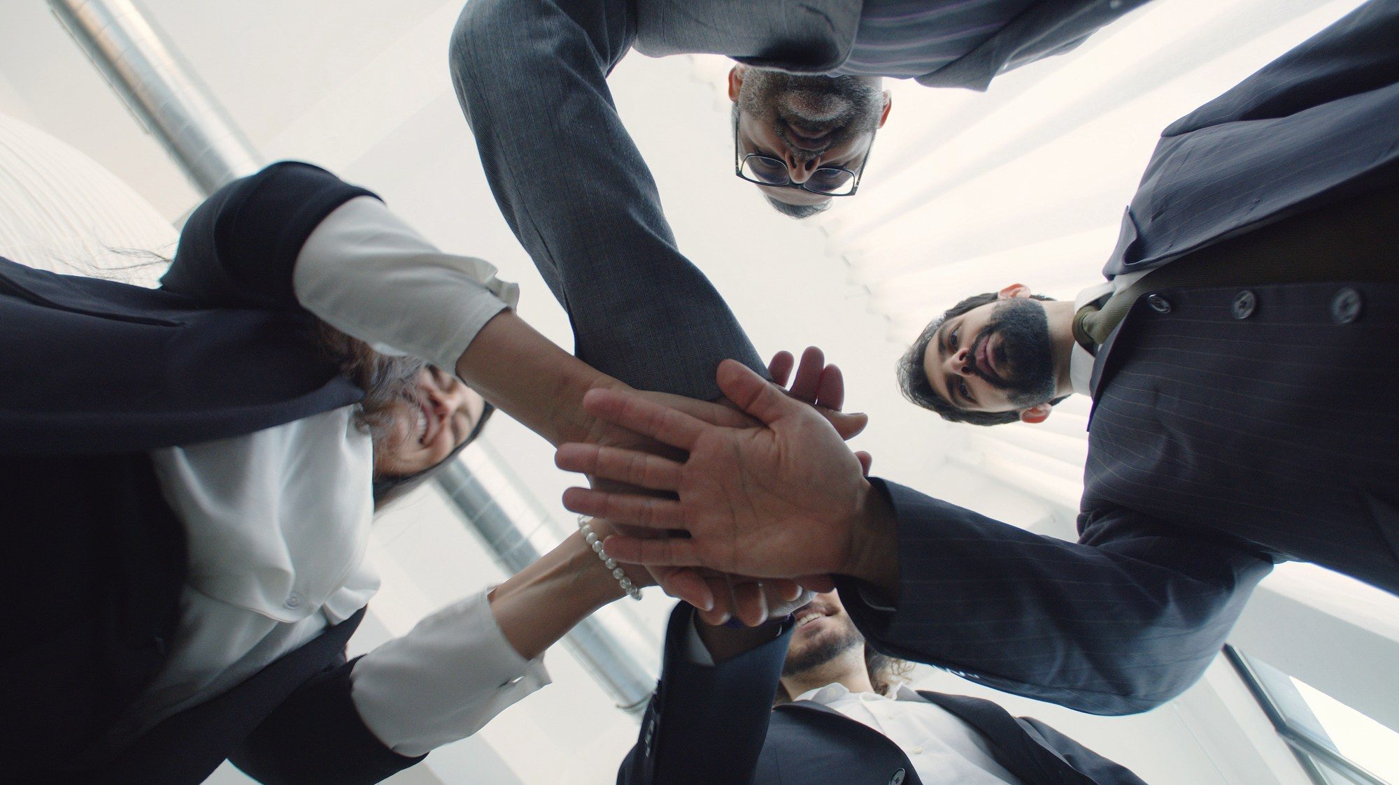 Équipe réunissant ses mains pour symboliser la coopération et l’intelligence collective